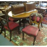 Victorian mahogany dining table of oval form standing on a carved and scrolled quatreform base,