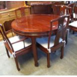 Modern hardwood Oriental circular extending dining table with two additional leaves and a set of