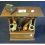 Small oak smokers stand with a collection of assorted smoking pipes including; Meerschaum with mask,