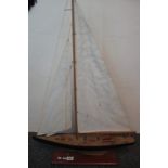 Modern wooden model of a sailing yacht with detailed deck fittings on wooden base,