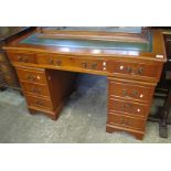 Reproduction mahogany, leather inset top, kneehole desk, having three drawers to each pedestal. (B.