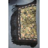 A vintage black ground floral design shawl with woven in gold floral and bird pattern and fringed
