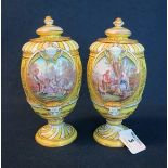A pair of Sevres porcelain urn shaped lidded vases on yellow ground with hand painted vignettes of