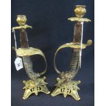 Pair of brass candlesticks fashioned from military swords,