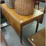 Pale oak Pembroke type drop leaf table on tapering legs. (B.P. 24% incl.