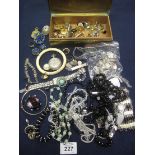 A box containing assorted costume jewellery, silver plated sovereign holder, silver fob,