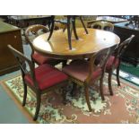 Victorian mahogany dining table of oval form standing on a carved and scrolled quatreform base,