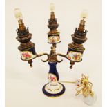 A three arm oil candelabra on French porcelain and brass, converted to electricity, c19th century,