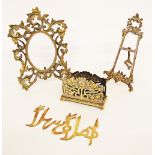 A small brass easel H25cm. An Arabic brass welcome note W20cm. A brass rococo style picture frame