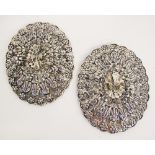 A pair of Persian silver mirrors of a scalloped oval shape with repousse / embossed concentric