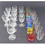 A collection of glasses comprising 11 footed wine glasses and 12 coloured tumblers (23)