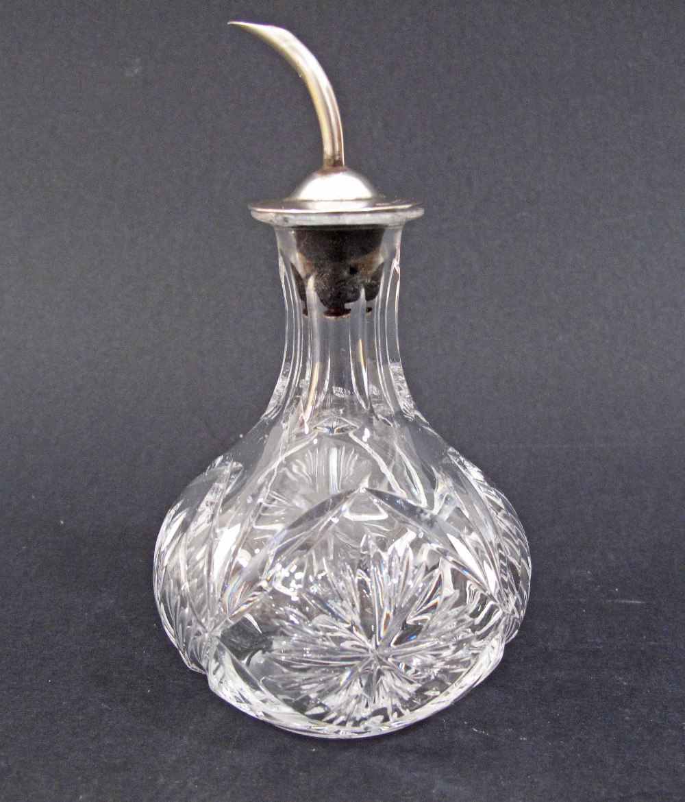 A lead crystal hand-cut vinegar bottle with a sterling silver pouring cup. The crystal H95mm.