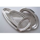 A collection of four silver plated oval meat platters with plain rims, the two larger Hallmarked