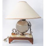 An Art Deco table lamp with a spherical body adorned by two dogs, on a wood and marble plinth. The