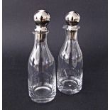 A pair of "Huile & Vinaigre" clear glass decanters with silver plated stoppers, H20cm. (4)