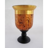 A gold leaf decorated footed glass vase on a wooden foot. H22cm.