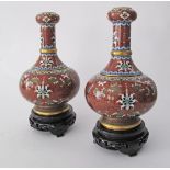 A pair of Chinese cloisonné bottle vases with an onion neck, decorated with flowers and rui on