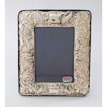 A sterling silver photo frame decorated with repousse motifs in the baroque style. 19X15cm.