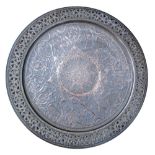 A large tinned copper round tray, probably Persian, repousse and engraved with Arabesque motifs in