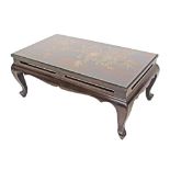 A Chinese lacquered long low table with open carved shaped frieze, raised on cabriole legs, the