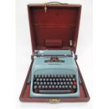 An Italian Olivetti Studio 44 portable typewriter in a burgundy cover, 38X43X20cm.