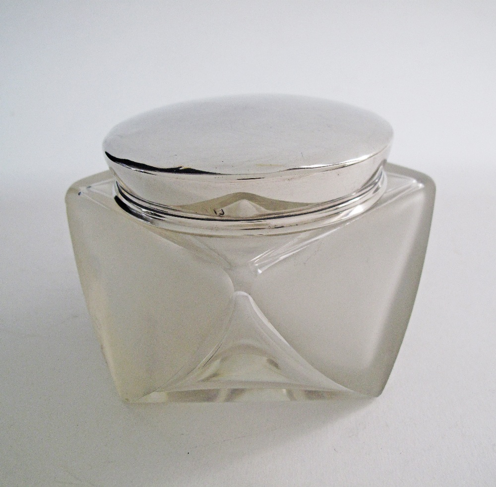 A modern etched frosted glass jar lidded with a silver cup.