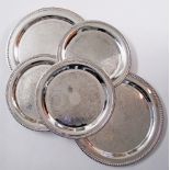 A collection of silver plated round serving dishes with engraved decoration and gadrooned rims.