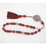 A red Amber and white metal worry bead