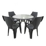 An iron and glass round garden table with 4 black plastic armchairs