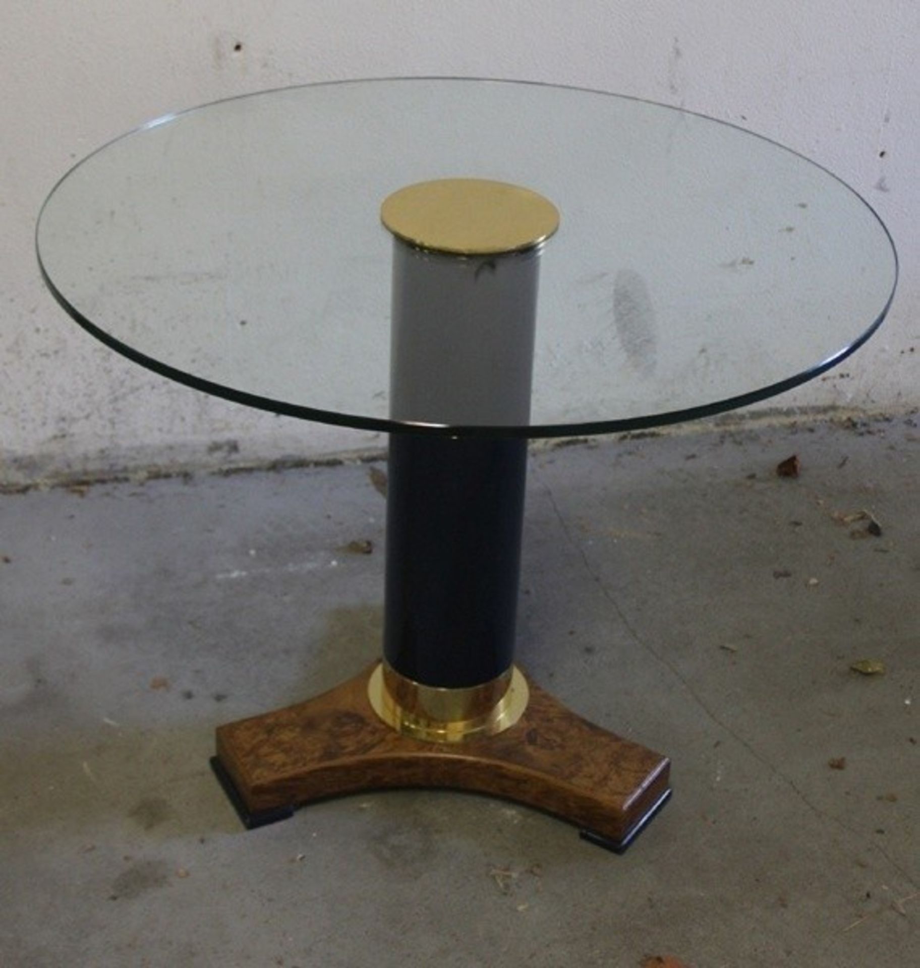 GlastischTisch mit runder Glasplatte, schwarzer Säulenschaft, auf Dreifuß mit brauner Maserung,