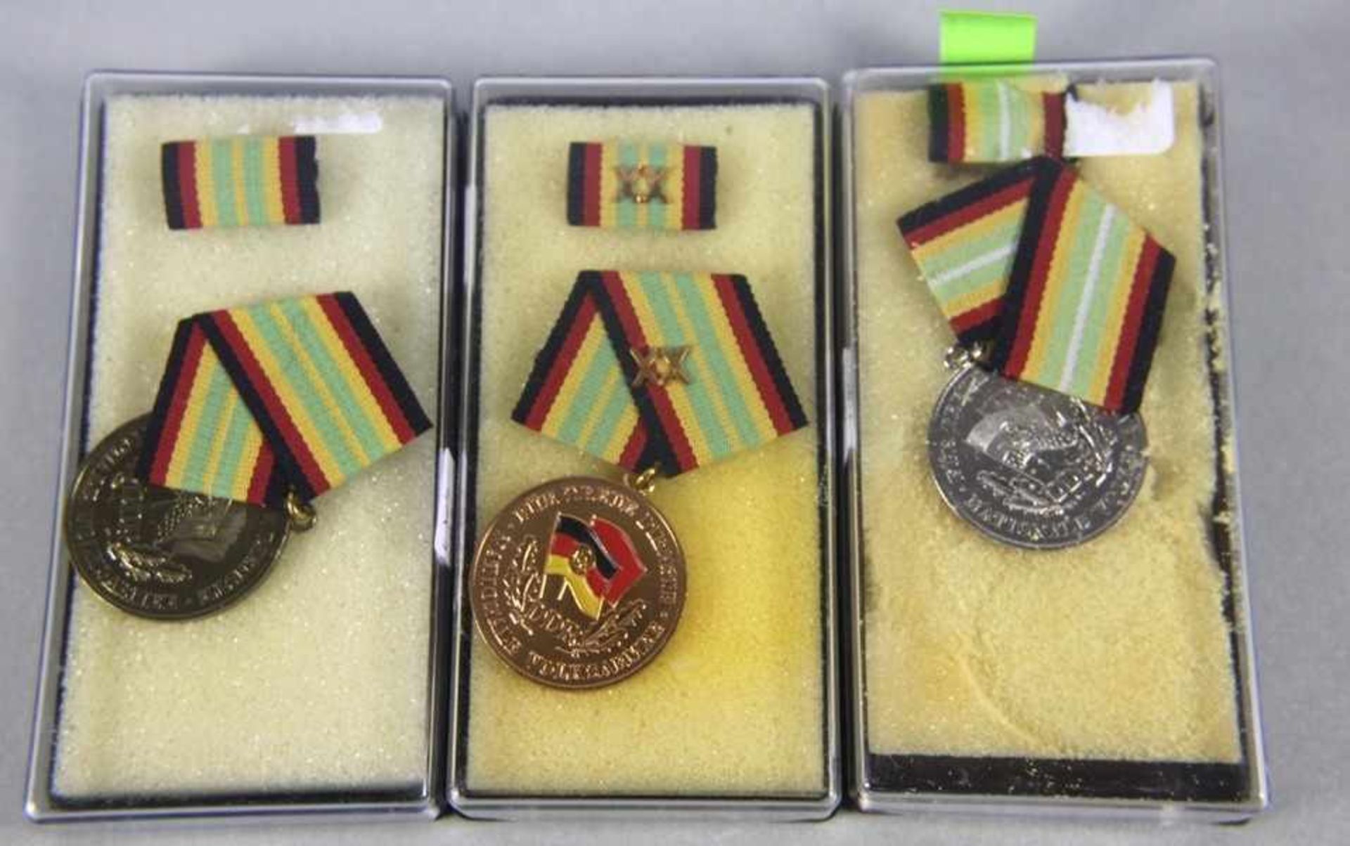 Konvolut NVA-Medaillenoriginal aus NVA-Beständen, 3 Stk. emaillierte Medaillen, Goldene Medaille für