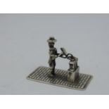 A Dutch Silver Miniature of a Blacksmith Hammering a Horseshoe on his Anvil - Hallmarked with the