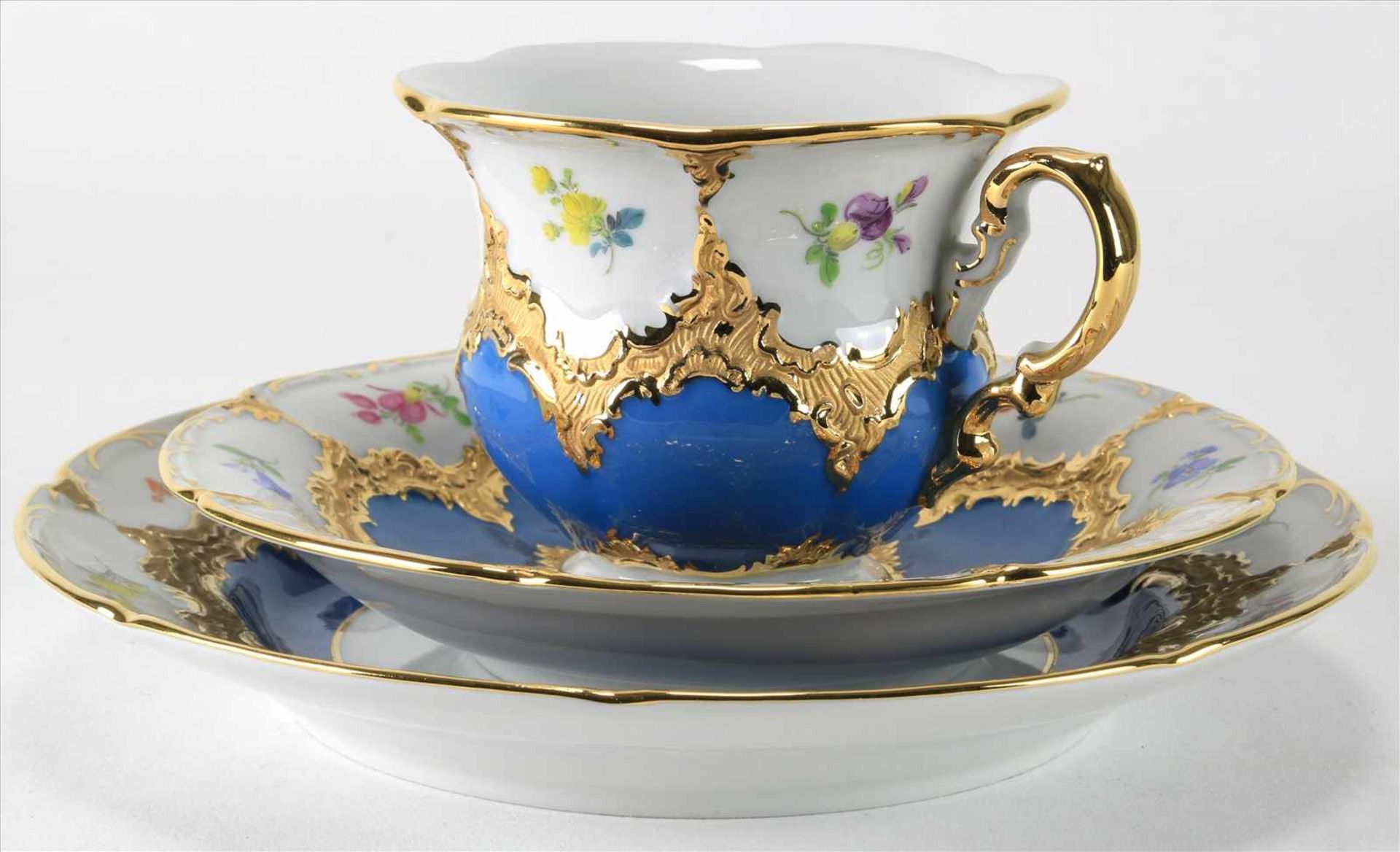 Kaffeegedeck MeissenUm 1950. B-Form mit Goldstaffage und Blümchendekor auf blau. Kuchenteller, Tasse