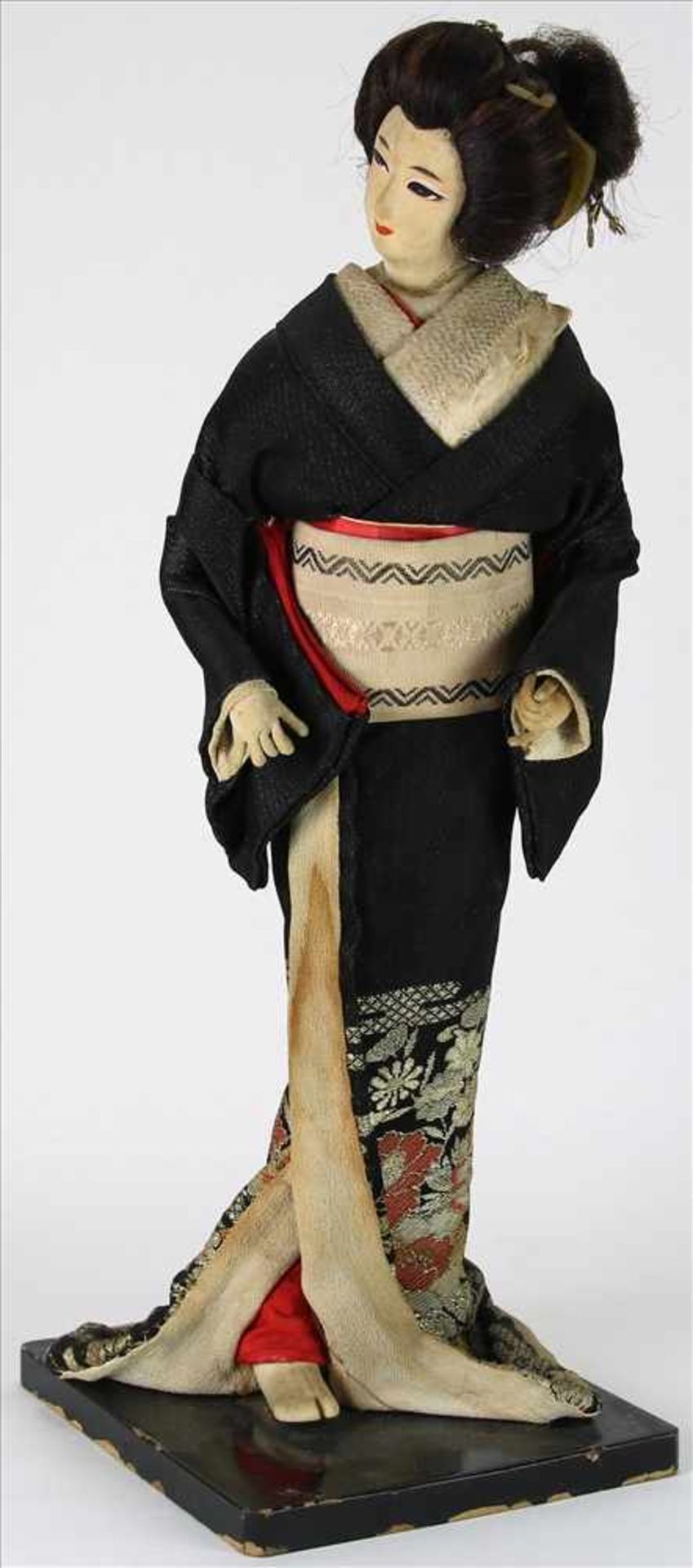 Nishi FigurJapan um 1900. Auf ebonisiertem Holzsockel, stehende Geisha mit reich besticktem Kimono