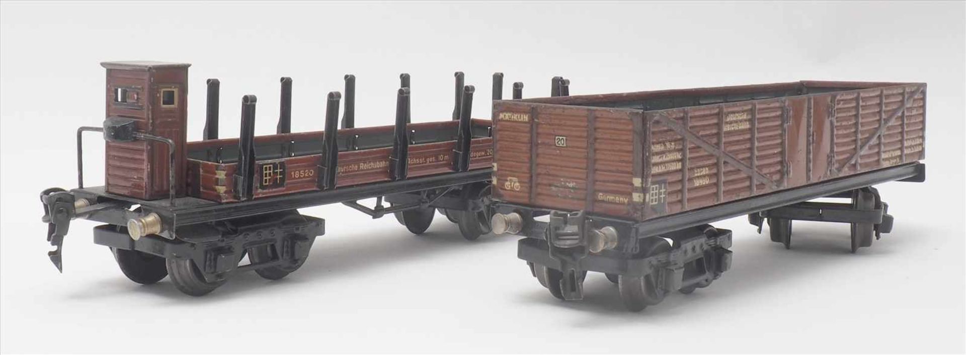 Zwei GüterwagenMärklin Spur 0. 1930-er Jahre. Hochbordwagen und Rungenwagen mit Bremserhaus.