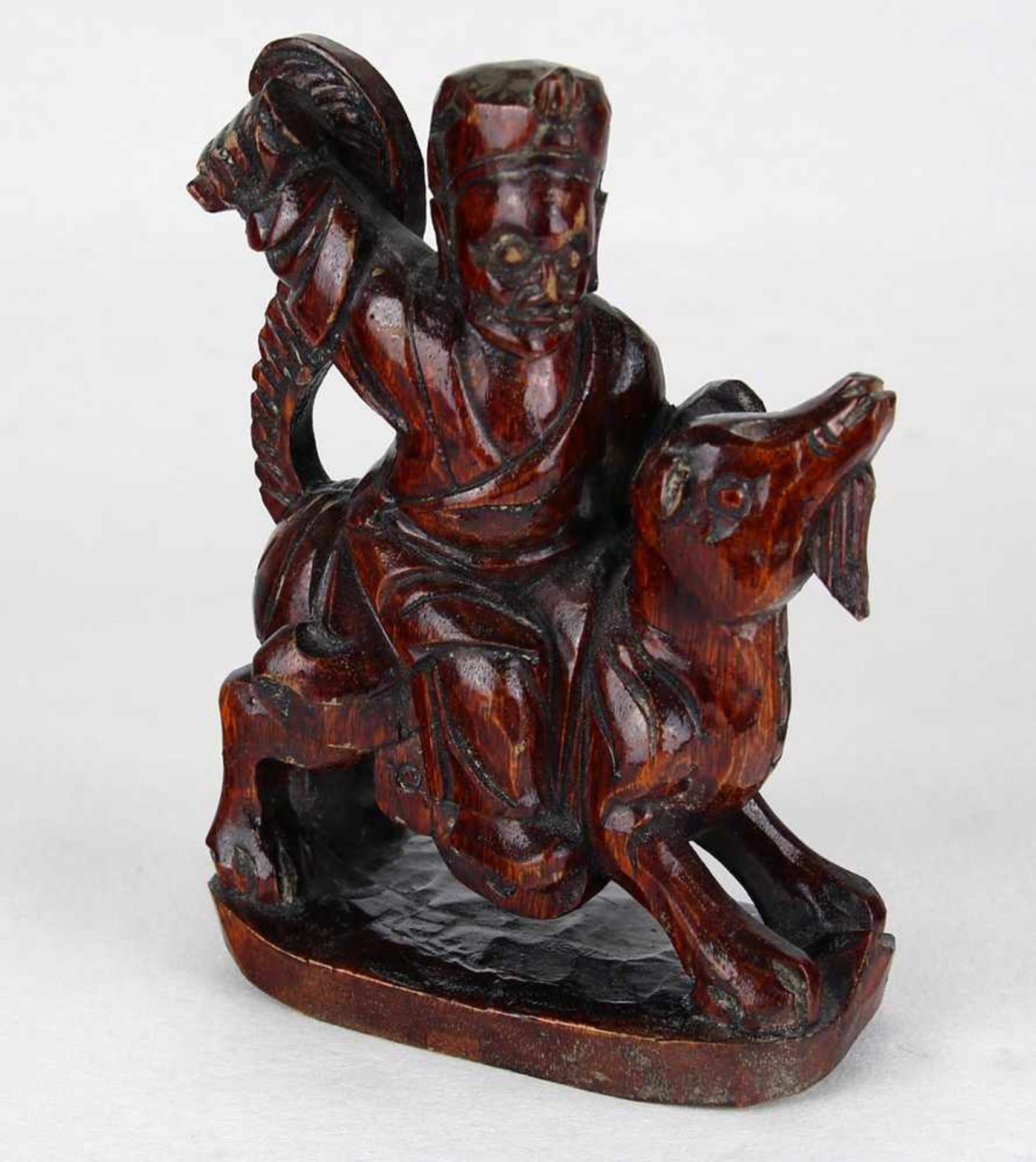 ReiterfigurChina um 1900. Holz geschnitzt und patiniert. Reiterfigur auf phantastischem Reittier.
