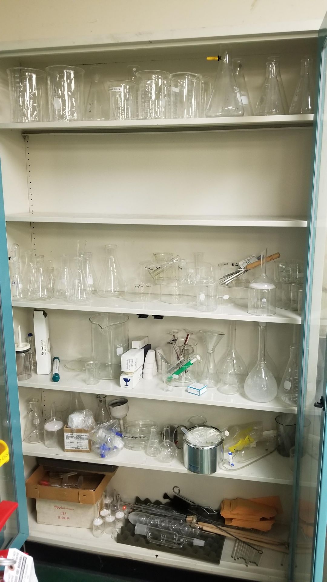 Large Lot of Glassware Located on Bench Top and in 2-Door Storage Cabinet