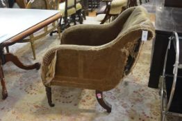 An early Victorian mahogany framed scroll back armchair, with downscrolled arms, raised on turned