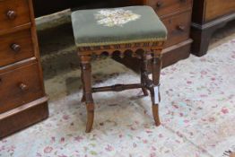 A small walnut dressing stool, the rectangular velvet seat above an apron with pendant carvings,