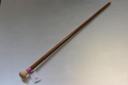 A 19th century ivory-mounted malacca walking cane, the flattened knop handle carved and incised with