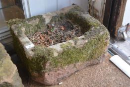 A rectangular weathered stone trough planter. 24cm by 47cm by 36cm