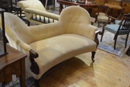 A mid-Victorian walnut-framed double spoon back sofa, the stuffed over seat flanked by scroll-carved