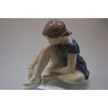 A Royal Copenhagen porcelain figure of a seated young ballerina, model no. 4642. Height 16cm