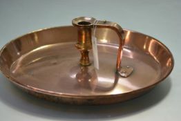 An unusual 19th century copper chamber stick, the very large pan centred by a baluster knop with