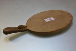 A Robert Thompson of Kilburn "Mouseman" oak cheese board, oval, with carved mouse signature.