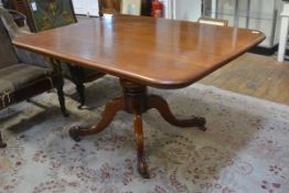 A Victorian mahogany breakfast table, the rectangular top with rounded corners raised on a massive