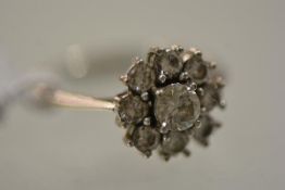 A diamond cluster ring, early 20th century, the central round brilliant-cut stone claw-set within