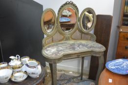 An Edwardian painted and canework dressing table, of kidney shape, the tripartite bevelled mirrors