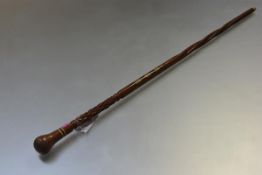 A 19th century walking cane, the handle of bulbous knop form over a striped inlaid band, the shaft