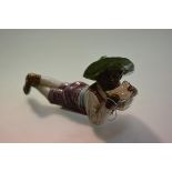 A 19th century majolica pottery figure of a recumbent negro boy eating melon, impressed marks to